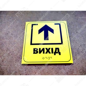 Тактильна табличка Вихід жовтого кольору з пластика з контрастною піктограмою та шрифтом Брайля - фотограія знизу