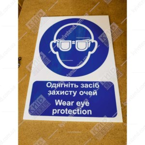 Знак безпеки Надягніть засіб захисту очей синього та білого кольору на пластиковій ламінованій основі фотографія  у виробничому приміщенні